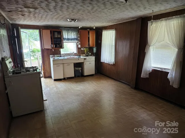 a kitchen with stainless steel appliances kitchen island granite countertop a stove a sink and a refrigerator