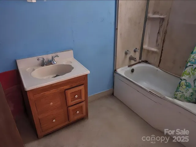 a bathroom with a tub sink and mirror