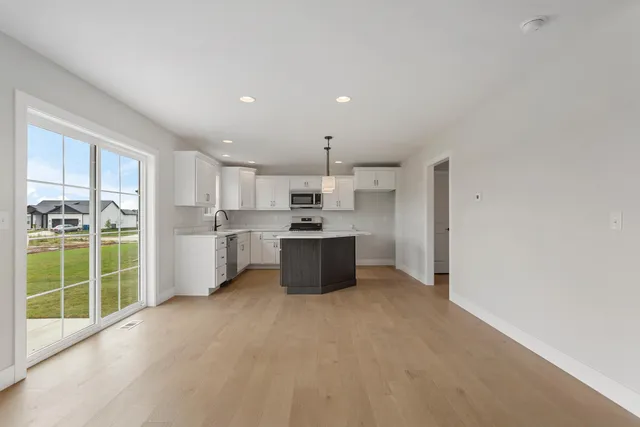 a large white kitchen with a sink and refrigerator