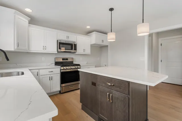 a kitchen with a sink a microwave and cabinets