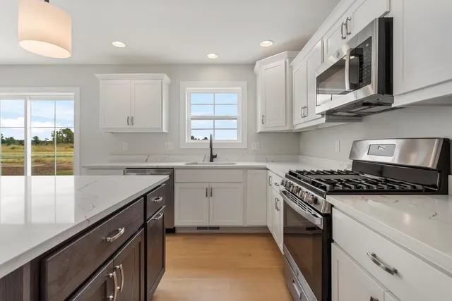 a kitchen with stainless steel appliances granite countertop a sink stove microwave and cabinets