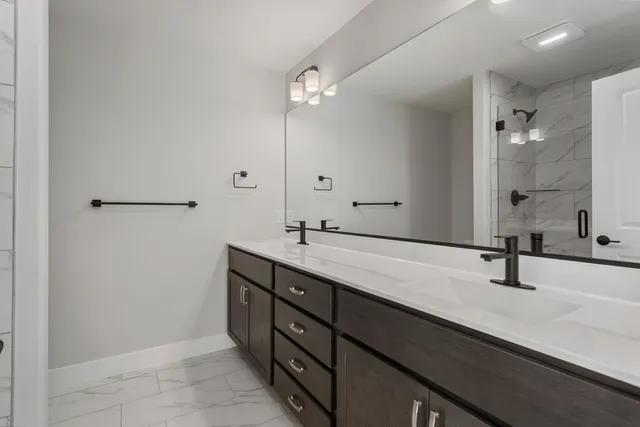 a bathroom with a double vanity sink a mirror and shower