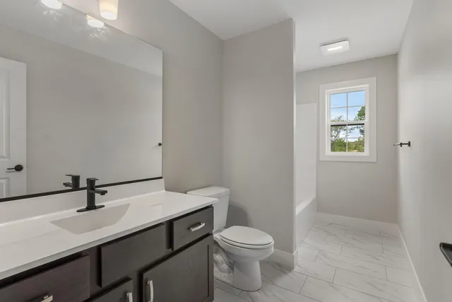 a bathroom with a sink a toilet and mirror