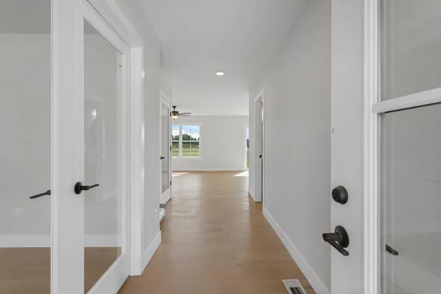 a view of a hallway with wooden floor and closet area
