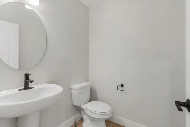 a bathroom with a sink a toilet and a mirror