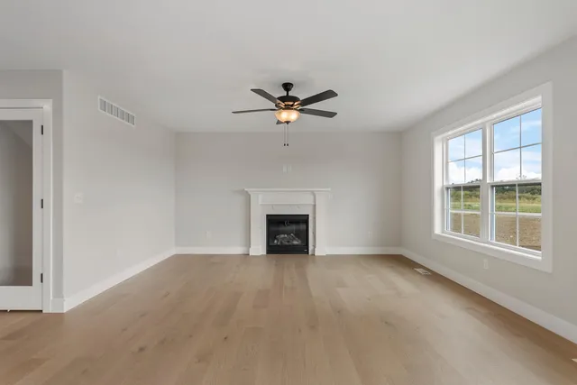 an empty room with fan and windows