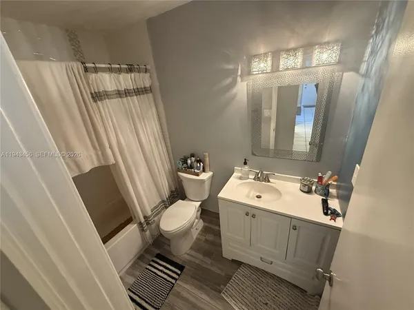 a bathroom with a sink and mirror with toilet