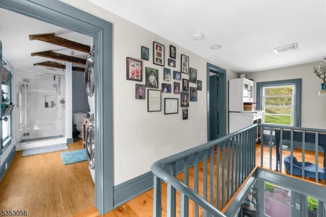 a view of a hallway with wooden floor and windows
