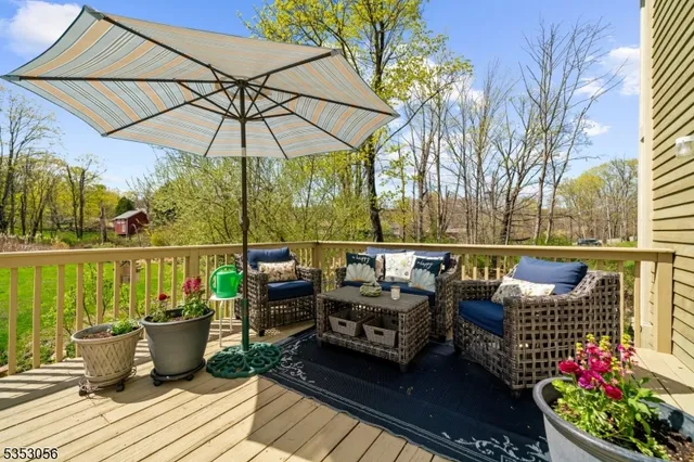 a roof deck with table and chairs under an umbrella