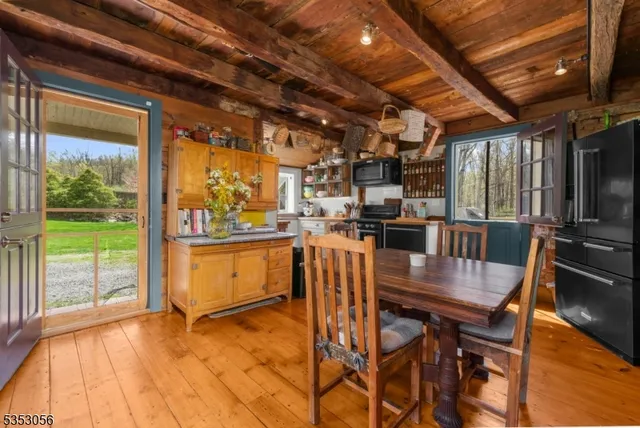 a dining room with furniture a floor to ceiling window and wooden floor