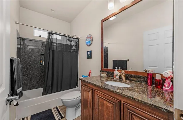 a bathroom with a granite countertop sink toilet and shower