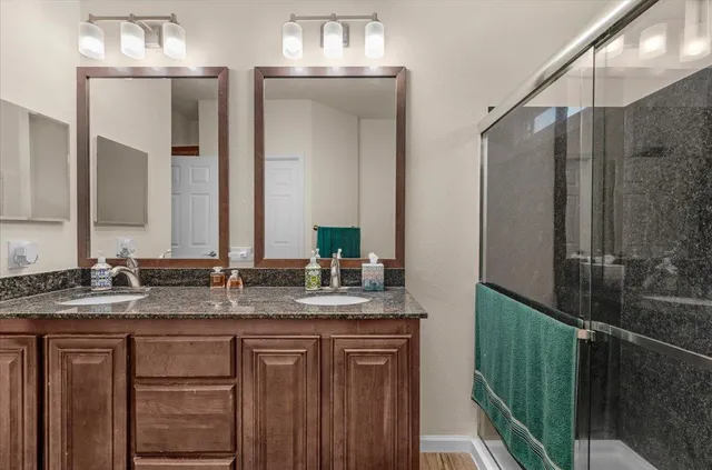 a bathroom with double sink and a mirror
