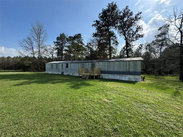 a kitchen with granite countertop white cabinets white appliances a sink and a window