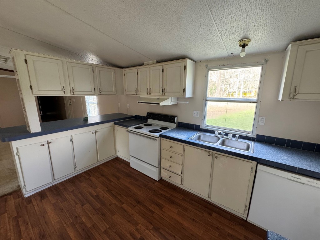 23278 Morgan Cemetery Road Splendora, TX 77372 - Photo 8 of 27 a kitchen with granite countertop white cabinets white appliances a sink and a window