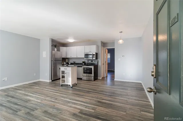 a view of kitchen with refrigerator microwave and stove top oven