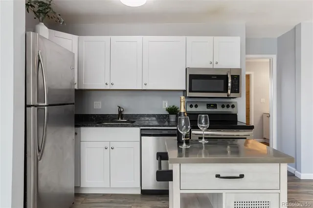 a kitchen with appliances a sink and cabinets