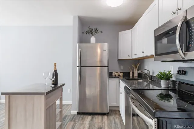 a kitchen with stainless steel appliances a refrigerator a sink a stove a microwave and cabinets