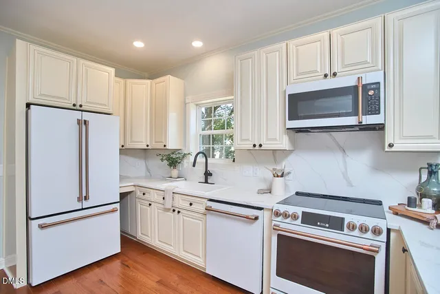 a kitchen with a sink stove cabinets and wooden floor