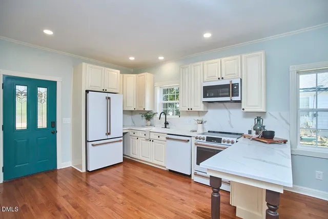 a kitchen with white cabinets and white appliances