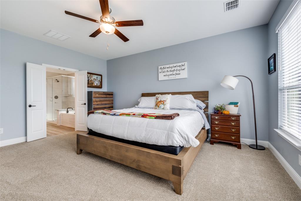 337 Augusta Court Oak Point, TX 75068 - Photo 13 of 26 a bed room with a bed and a chandelier