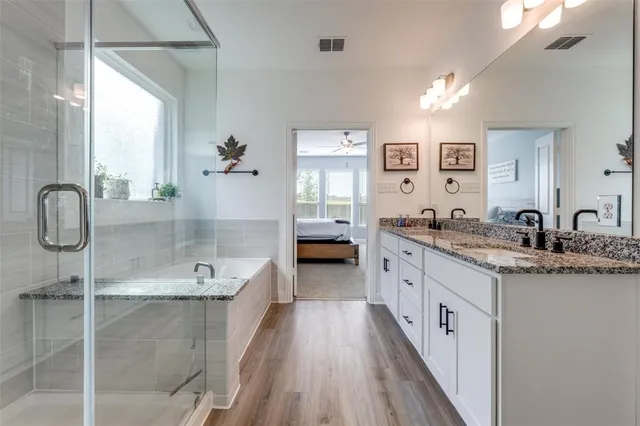 a spacious bathroom with a granite countertop tub sink and mirror