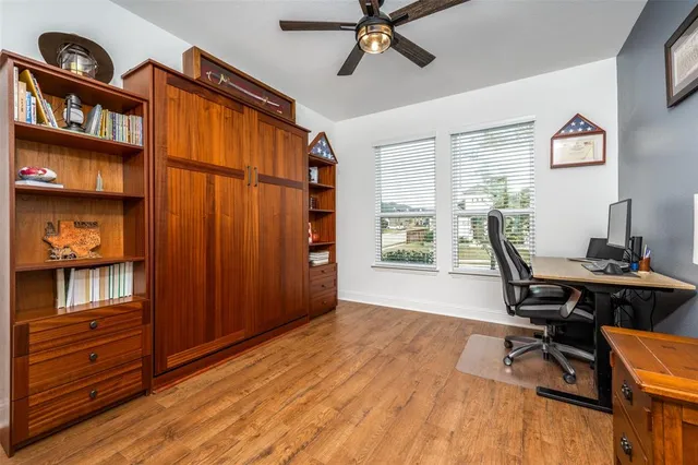 a view of a workspace with furniture and a window