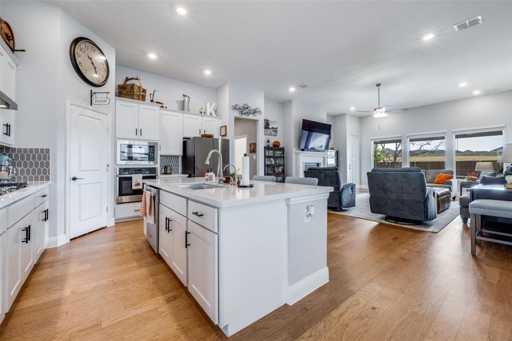 337 Augusta Court Oak Point, TX 75068 - Photo 6 of 26 a kitchen with stainless steel appliances kitchen island granite countertop a stove and a wooden floors