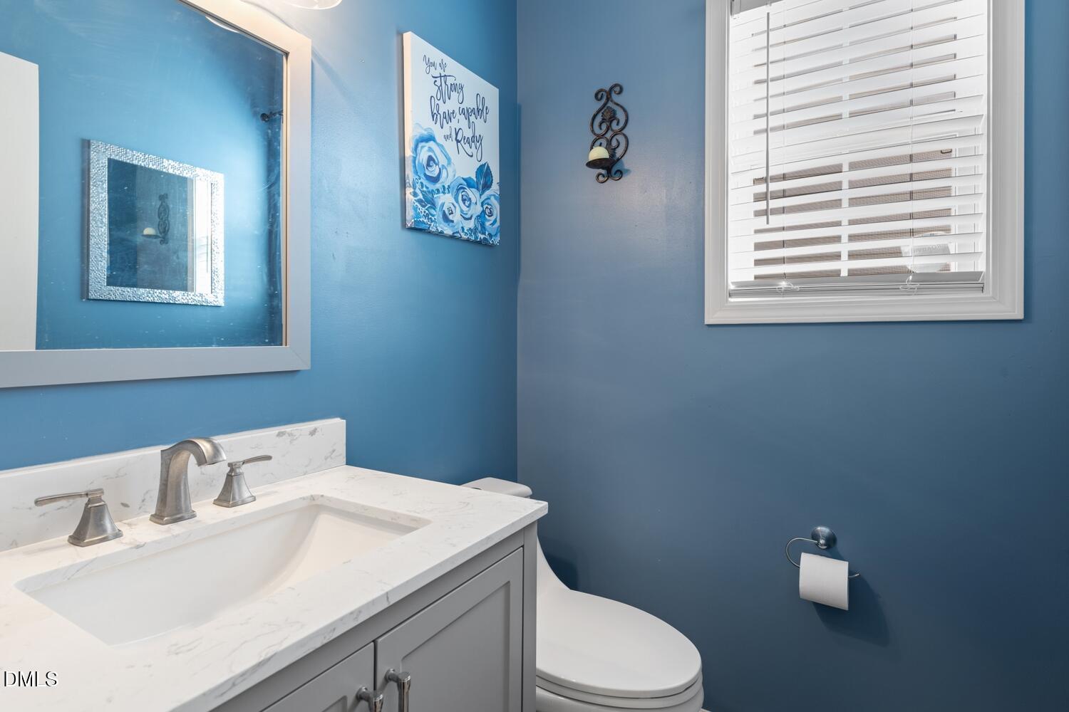 4113 Lady Slipper Lane Durham, NC 27704 - Photo 12 of 28 a bathroom with a toilet sink and mirror