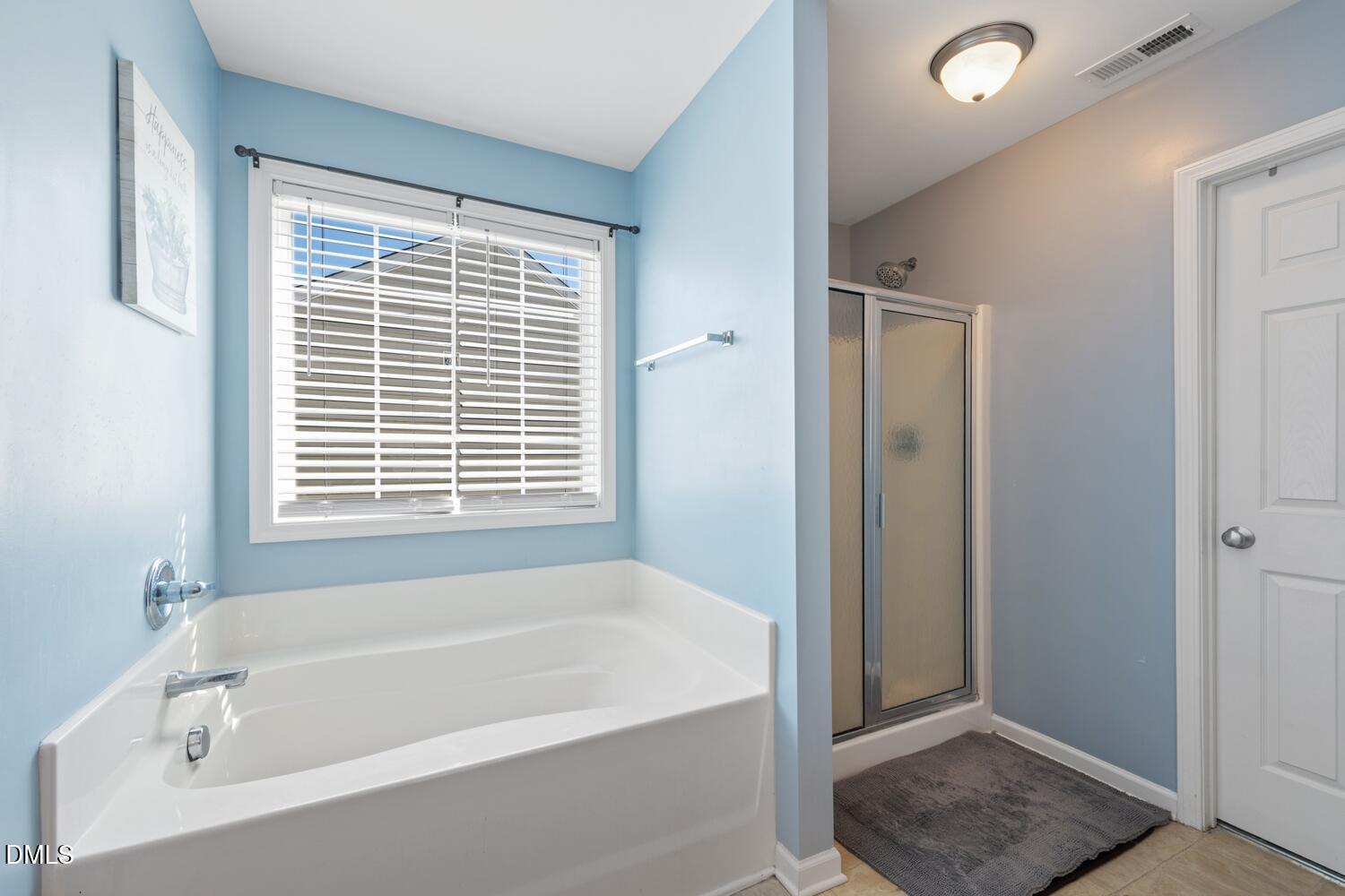 4113 Lady Slipper Lane Durham, NC 27704 - Photo 17 of 28 a bathroom with a bathtub and a shower