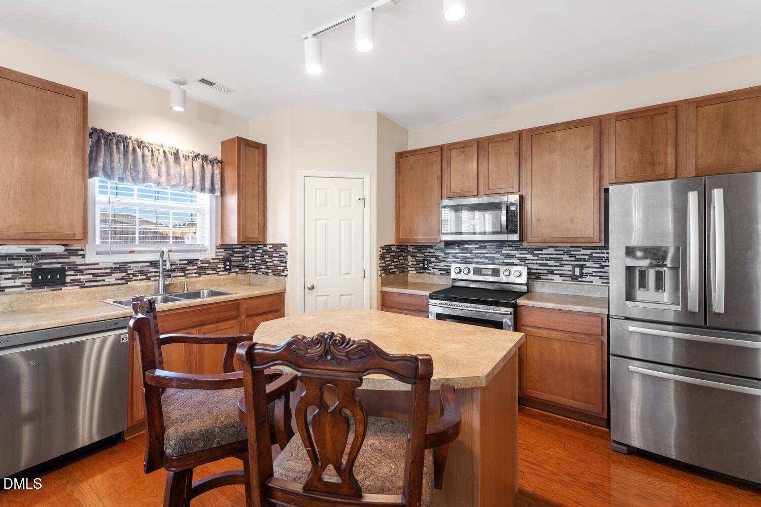 4113 Lady Slipper Lane Durham, NC 27704 - Photo 3 of 28 a kitchen with kitchen island granite countertop wooden cabinets and stainless steel appliances
