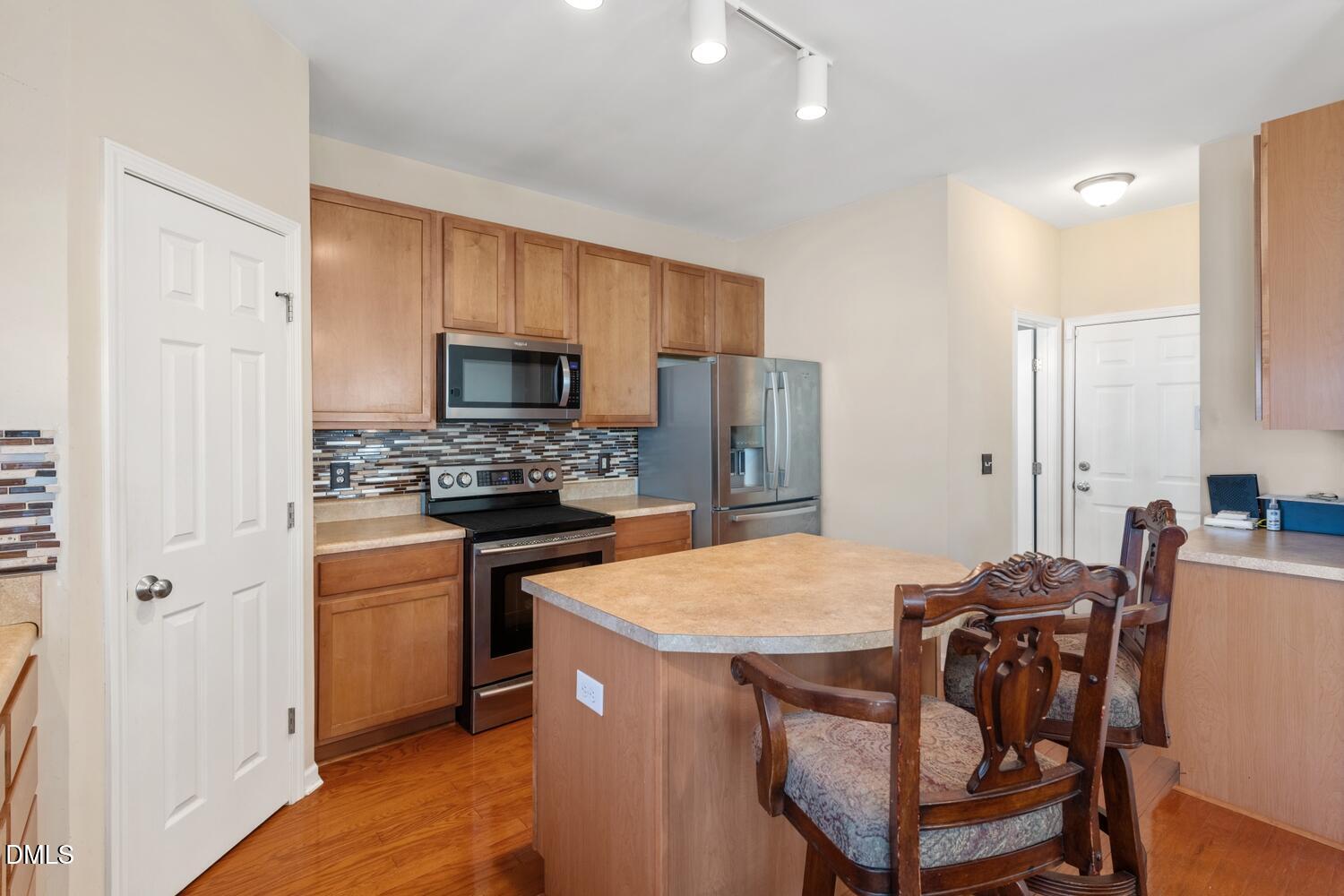 4113 Lady Slipper Lane Durham, NC 27704 - Photo 10 of 28 a kitchen with a table chairs refrigerator and microwave