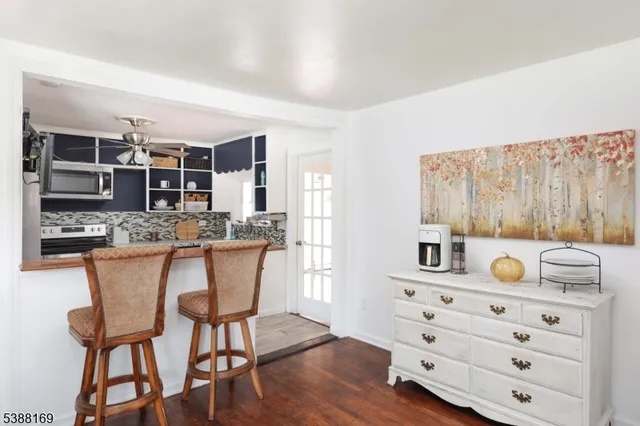 a kitchen with stainless steel appliances kitchen island granite countertop a table chairs in it and wooden floors