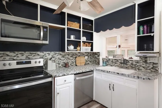 a kitchen with stainless steel appliances kitchen island a stove a sink and a microwave