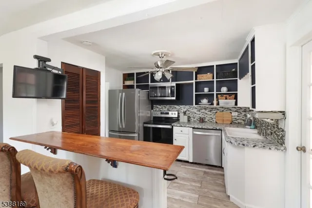 a kitchen with kitchen island a sink stainless steel appliances and cabinets