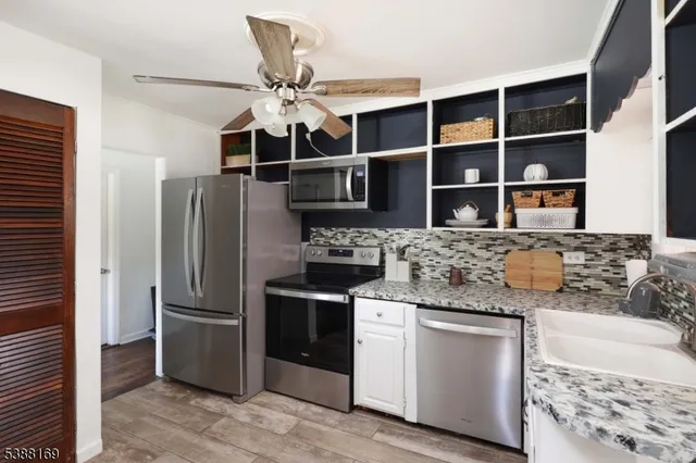 a kitchen with stainless steel appliances granite countertop a refrigerator and a sink