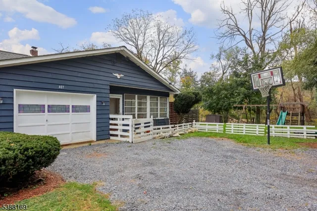 a view of a house with a yard and large tree