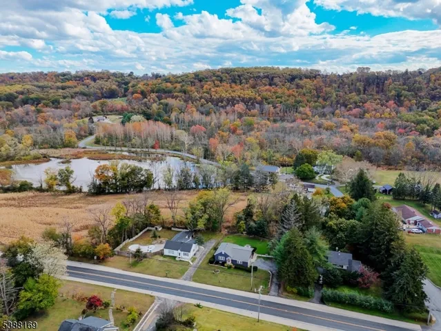 an aerial view of a house with yard swimming pool and lake view