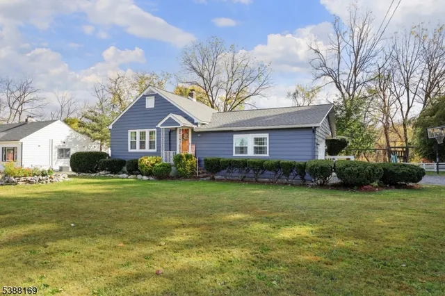 a front view of a house with garden and trees