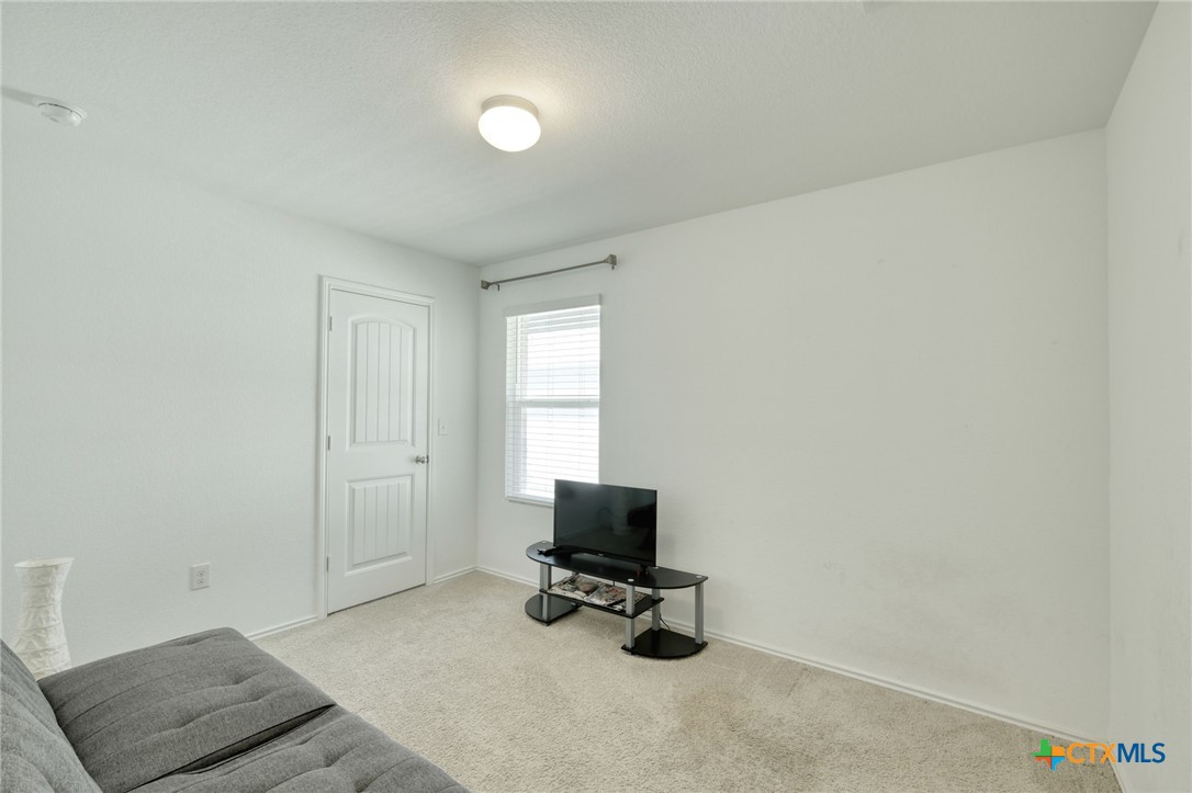 14905 Breccia Road Manor, TX 78653 - Photo 7 of 13 Secondary bedroom with carpet and window for natural light.