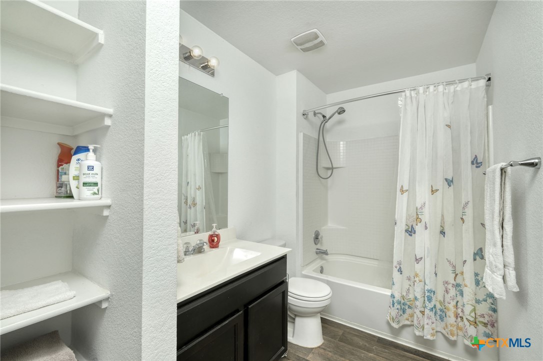 14905 Breccia Road Manor, TX 78653 - Photo 8 of 13 The secondary bathroom has a single vanity, full bath with shower/tub combo, and built in shelves.