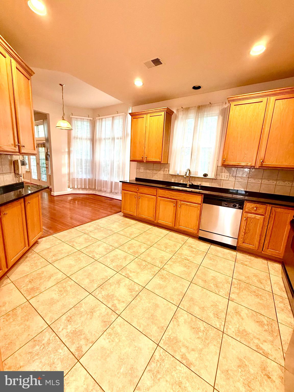 12447 Red Patch Lane Fairfax, VA 22033 - Photo 11 of 34 a large kitchen with kitchen island granite countertop a large window and a counter top space