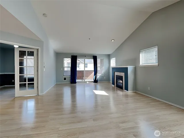 a view of empty room with wooden floor and fireplace