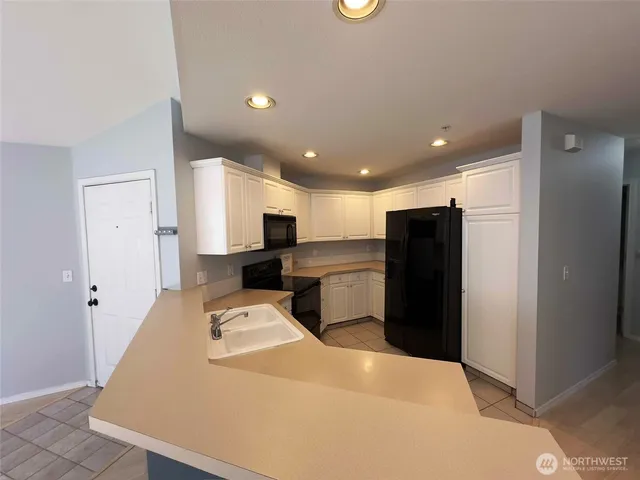 a large kitchen with stainless steel appliances kitchen island a refrigerator sink and microwave