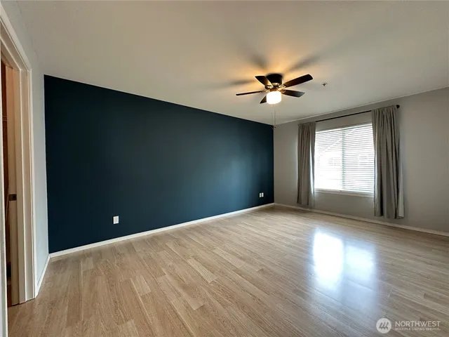a view of a room with a ceiling fan and wooden floor