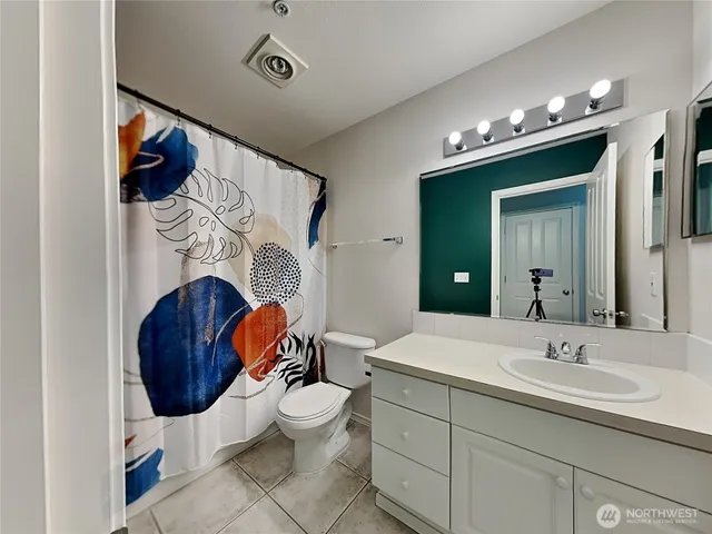 a bathroom with a sink vanity mirror and toilet