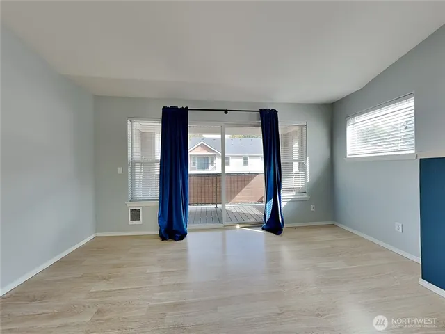 an empty room with sliding door and wooden floor