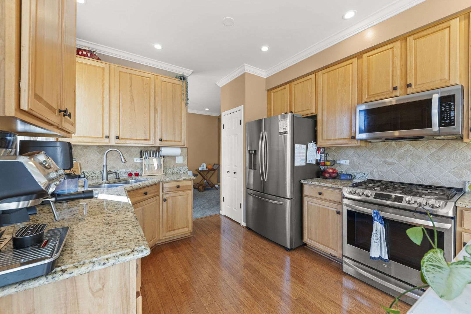 2723 Rosehall Lane Aurora, IL 60503 - Photo 9 of 23 a kitchen with stainless steel appliances granite countertop a stove top oven a refrigerator a sink and dishwasher with wooden floor