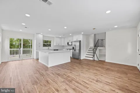 a view of large kitchen with wooden floor and windows