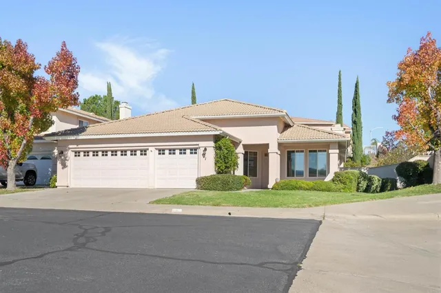 a front view of a house with a garden and plants