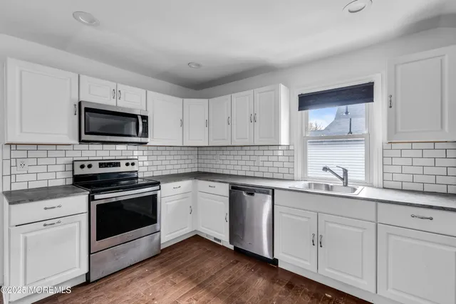a kitchen with a sink stove and microwave